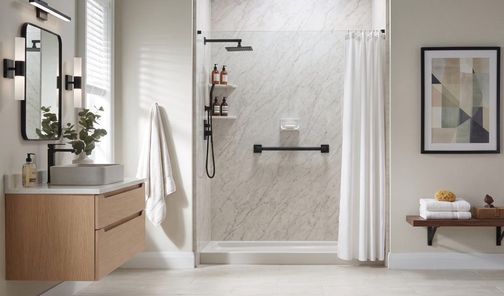 Modern bathroom alcove converted into a walk-in shower featuring white marble walls, black hardware, a rainfall showerhead, a black grab bar, and a white shower curtain drawn to the side.
